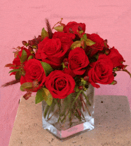 n elegant display of roses in the color of your choice, tastefully arranged with complimenting filler flowers and / or green foliage, in a heavy glass rectangular vase.